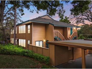 Inviting multi-level condo featuring wood siding, a covered parking area, and well-maintained landscaping at 1208 Cypress Pond Rd, Palm Harbor, FL 34683