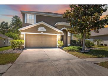 Charming two-story home with a well-manicured lawn, mature landscaping, and a two-car garage at 18331 Waydale Loop, Hudson, FL 34667
