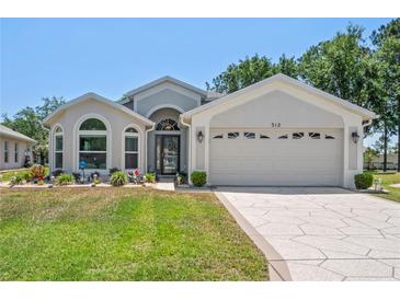 Charming single-story home featuring a well-manicured lawn and a two-car garage at 312 Barrington Ct, Spring Hill, FL 34609