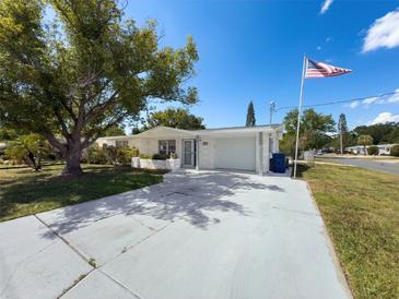 Charming single-story home boasts a brick facade, spacious driveway, and a well-manicured lawn at 6431 Gainsboro Dr, Port Richey, FL 34668