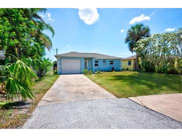 Charming one-story home with a well-manicured lawn, bright blue paint, and a long driveway at 6432 Boatyard Dr, Hudson, FL 34667