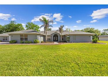 Charming single-story home featuring a well-manicured lawn, double-door entryway, and tasteful landscaping at 7466 Jonquil Pl, Weeki Wachee, FL 34607