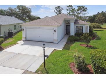 Charming single-story home featuring well-manicured lawn, two-car garage, and a welcoming front entrance at 11732 Wheatfield Loop, Hudson, FL 34667