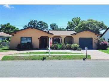 Charming single story home featuring an arched entryway and an attached garage at 13111 Sheridan Dr, Hudson, FL 34667