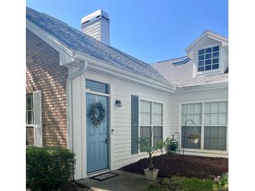 Charming home exterior showcasing a quaint blue front door with wreath and well-maintained landscaping at 2729 Penzance St, Palm Harbor, FL 34684