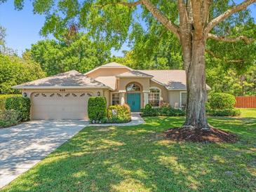 Charming single-story home with a well-manicured lawn and mature trees, showcasing a welcoming curb appeal at 446 Romine Ct, Spring Hill, FL 34609