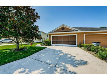 Charming home featuring a two-car garage, complemented by a driveway and front yard at 8604 Corinthian Way, New Port Richey, FL 34654