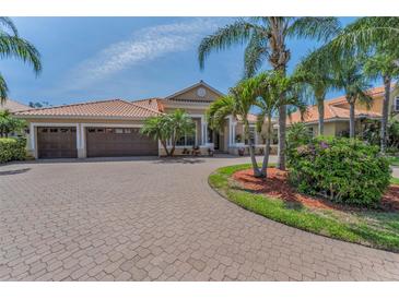 Charming home with a three car garage, brick paved driveway, and lush tropical landscaping at 1033 Tuscany Dr, Trinity, FL 34655