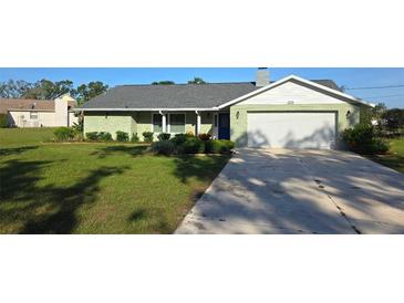 Charming single-story home with a well-manicured lawn and a two car garage at 273 Gulfport Ln, Spring Hill, FL 34608