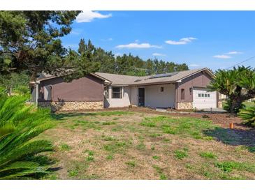 Charming single story home featuring wood paneled and stone exterior with a well maintained lawn, and attached garage at 3029 Harrow Rd, Spring Hill, FL 34606