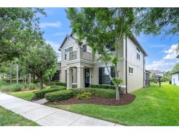 Charming two-story home featuring a balcony, black shutters, and a well-manicured front yard with lush landscaping at 3057 Riders Pass, Odessa, FL 33556