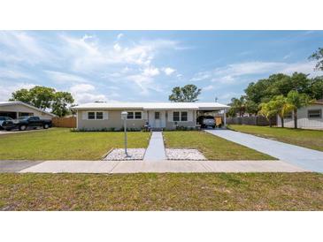 Charming single-story home featuring a well-maintained lawn and covered parking at 5031 Essex Ln, Spring Hill, FL 34606