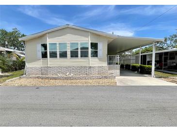 Well-maintained mobile home featuring a covered carport and manicured gravel landscaping at 585 Sky Harbor Dr # 219, Clearwater, FL 33759