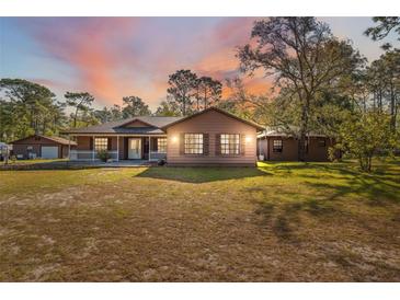 Charming single-story home with a welcoming front porch and picturesque sunset backdrop at 6080 Dexter Ln, Brooksville, FL 34602