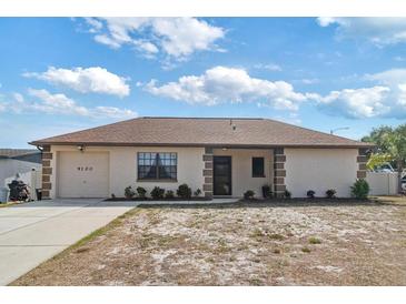Charming single-story home featuring a well-manicured lawn and an attached one-car garage at 9100 Whitman Ln, Port Richey, FL 34668