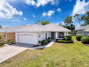 Charming single-story home with a well-maintained lawn, mature landscaping, and an attached two-car garage at 9237 Penelope Dr, Weeki Wachee, FL 34613