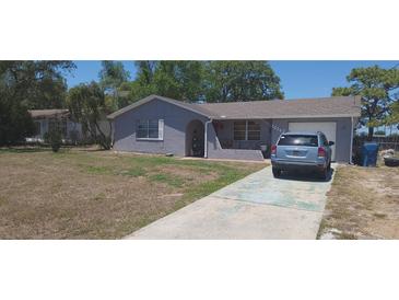 Charming home featuring a stucco exterior, well-maintained lawn, and convenient driveway parking at 10347 Caspian St, Spring Hill, FL 34608