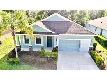 Charming, light blue single-Gathering home with a two-car garage and lush landscaping at 11041 Paradise Point Way, New Port Richey, FL 34654
