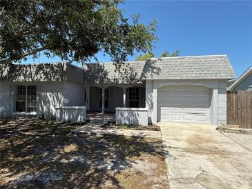Charming single-story home featuring an attached garage, a brick walkway, and mature landscaping at 3617 Rockaway Dr, Holiday, FL 34691