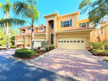 Charming townhouse featuring a tile roof, two-car garage, and lush landscaping at 3655 Square West Ln # 9, Sarasota, FL 34238