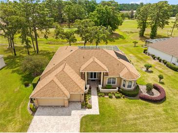 Beautiful home featuring mature landscaping, a screened pool, and a brick paver driveway and entryway at 5164 Golf Club Ln, Spring Hill, FL 34609