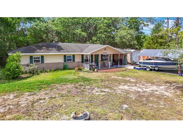 Charming one-story home featuring a covered front porch and a well-maintained lawn with mature trees at 6203 Sumter Dr, Brooksville, FL 34602