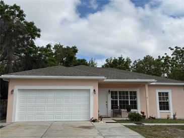 Charming single-story home featuring an attached garage, well-maintained lawn, and front door seating area at 7144 Gulf Breeze Cir, Hudson, FL 34667