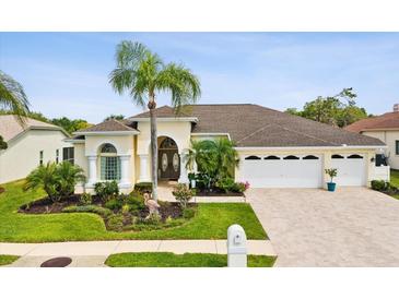 Charming single-story home featuring a well-manicured lawn and a spacious three-car garage at 8137 Morning View Dr, Hudson, FL 34667