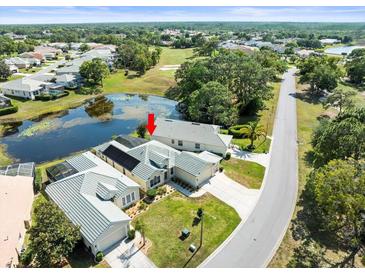 Aerial view of a well-maintained single-Gathering home next to a pond with a screened in pool at 9010 Penelope Dr, Weeki Wachee, FL 34613