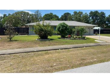 Charming single-story home featuring a well-manicured lawn and mature landscaping at 9186 Patio Ct, Spring Hill, FL 34608