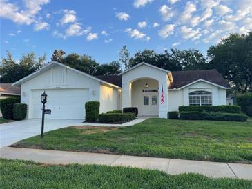 Charming single-story home with a well-maintained lawn, double door entry, and attached two-car garage at 11213 Brooklawn Dr, Hudson, FL 34667