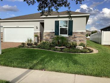 Charming single-Gathering home features manicured lawn, stone accents, and a two-car garage at 12630 Aston Dr, Hudson, FL 34669
