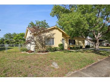 Charming single-story home with a well-maintained lawn, landscaping, and a fenced yard at 12906 Sandburst Ln, Hudson, FL 34667