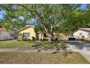Charming single-story home featuring a well-manicured lawn and mature trees at 12906 Sandburst Ln, Hudson, FL 34667