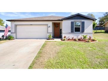 Charming single-story home featuring a well-maintained lawn, inviting front door, and a convenient two-car garage at 13205 Arkendale St, Spring Hill, FL 34609