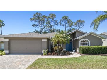 Well-maintained single-story home featuring an attached two-car garage and a beautifully landscaped front yard at 18532 Myrtlewood Dr, Hudson, FL 34667