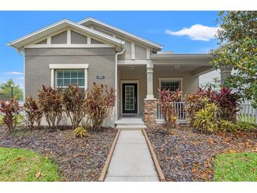 Charming single-story home features a landscaped front yard and covered porch with stone accents at 21167 Pleasant Plains Pkwy, Land O Lakes, FL 34637