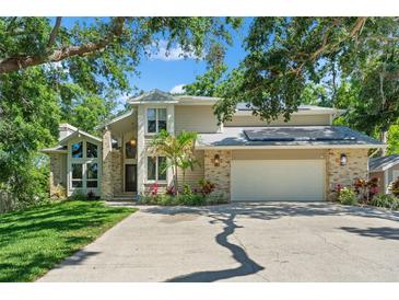 Beautiful two-story home with attached two-car garage, lush landscaping, and lovely brick and siding exterior at 520 Lafayette Blvd, Oldsmar, FL 34677
