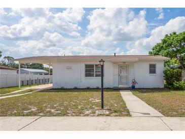 Charming single-story home with a covered carport, neatly kept lawn, and neutral color scheme at 7050 Merrick Ln, Spring Hill, FL 34606