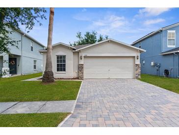 Charming single-story home featuring a paved driveway, two-car garage, and well-maintained lawn at 3410 Thistledown Ln, Land O Lakes, FL 34638