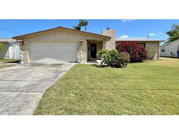 Charming single-story home featuring an attached garage and a well-maintained lawn with attractive landscaping at 4333 Baden Dr, Holiday, FL 34691
