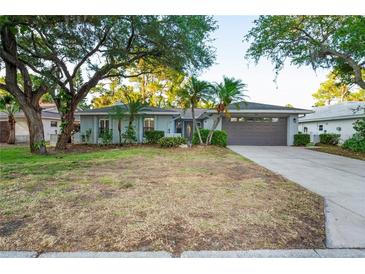 Charming single-story home featuring mature trees, well-kept landscaping, and a two-car garage at 4369 Marine Pkwy, New Port Richey, FL 34652