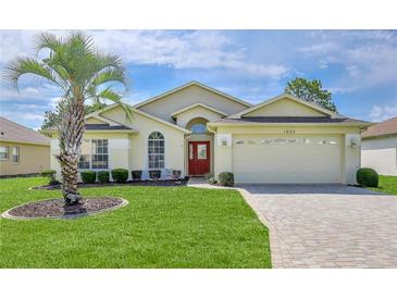 Charming single-story home featuring a well-manicured lawn and inviting red front door at 1032 Walnut Hill Ct, Spring Hill, FL 34609
