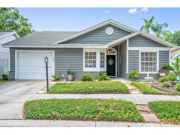 Charming one-story home with gray siding, manicured landscaping, and a cozy front porch at 1486 Loman Ct, Palm Harbor, FL 34683