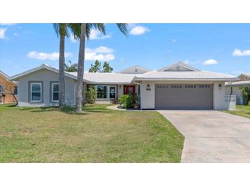 Charming single-story home featuring a two-car garage, red front door, and well-maintained lawn at 4918 Forecastle Dr, New Port Richey, FL 34652