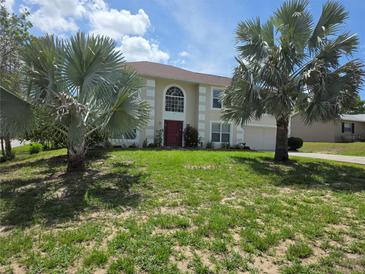 Charming two-story home with lush front lawn, beautiful trees, and inviting red front door at 6440 Curtiss Ln, Spring Hill, FL 34608