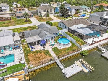 Stunning waterfront property with a backyard pool and a private dock for boating and enjoying the coastal lifestyle at 7626 Hatteras Dr, Hudson, FL 34667