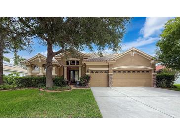 Charming single-story home with a well-manicured lawn, mature trees, and a spacious three-car garage at 9124 Topneck St, New Port Richey, FL 34654