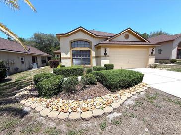 Charming single-story home with a well-manicured lawn, decorative rock border and inviting curb appeal at 9311 Haas Dr, Hudson, FL 34669