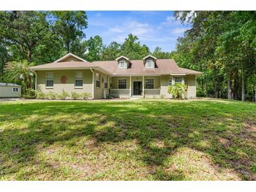 Charming single-story home with a spacious front yard and mature trees at 14145 Citrus Way, Brooksville, FL 34601
